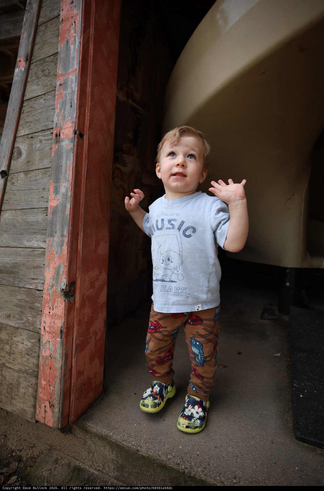 Young Child's Wonder in Rustic Doorway