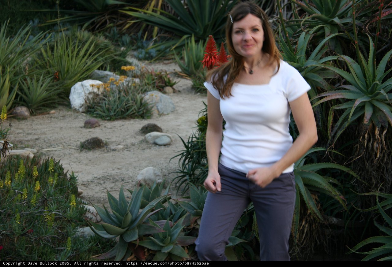 Woman Smiling Among Desert Succulents and Cacti