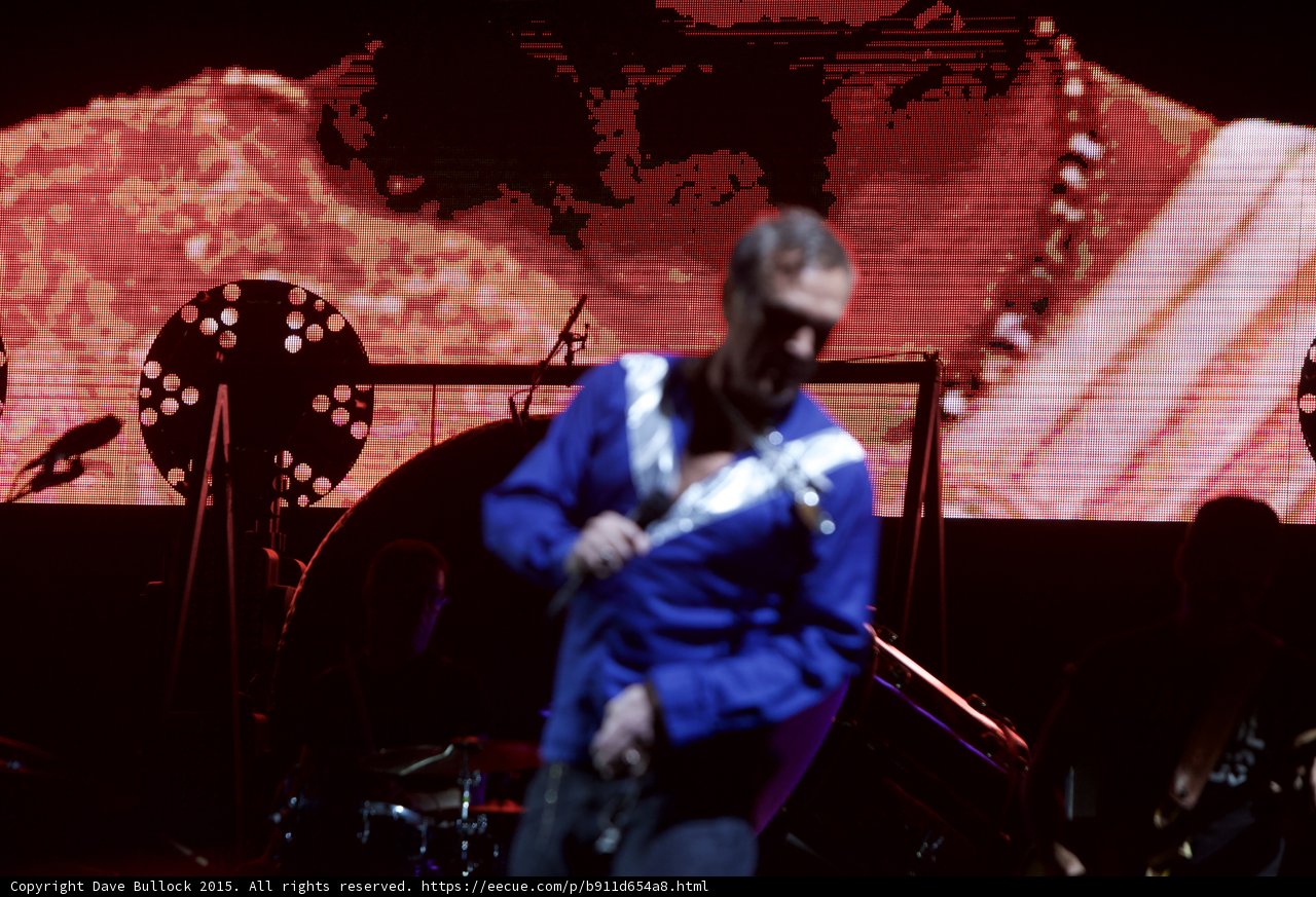 Morrissey Motion Blur Looking Down Blue Shirt Circular Light Large Red Video Screen