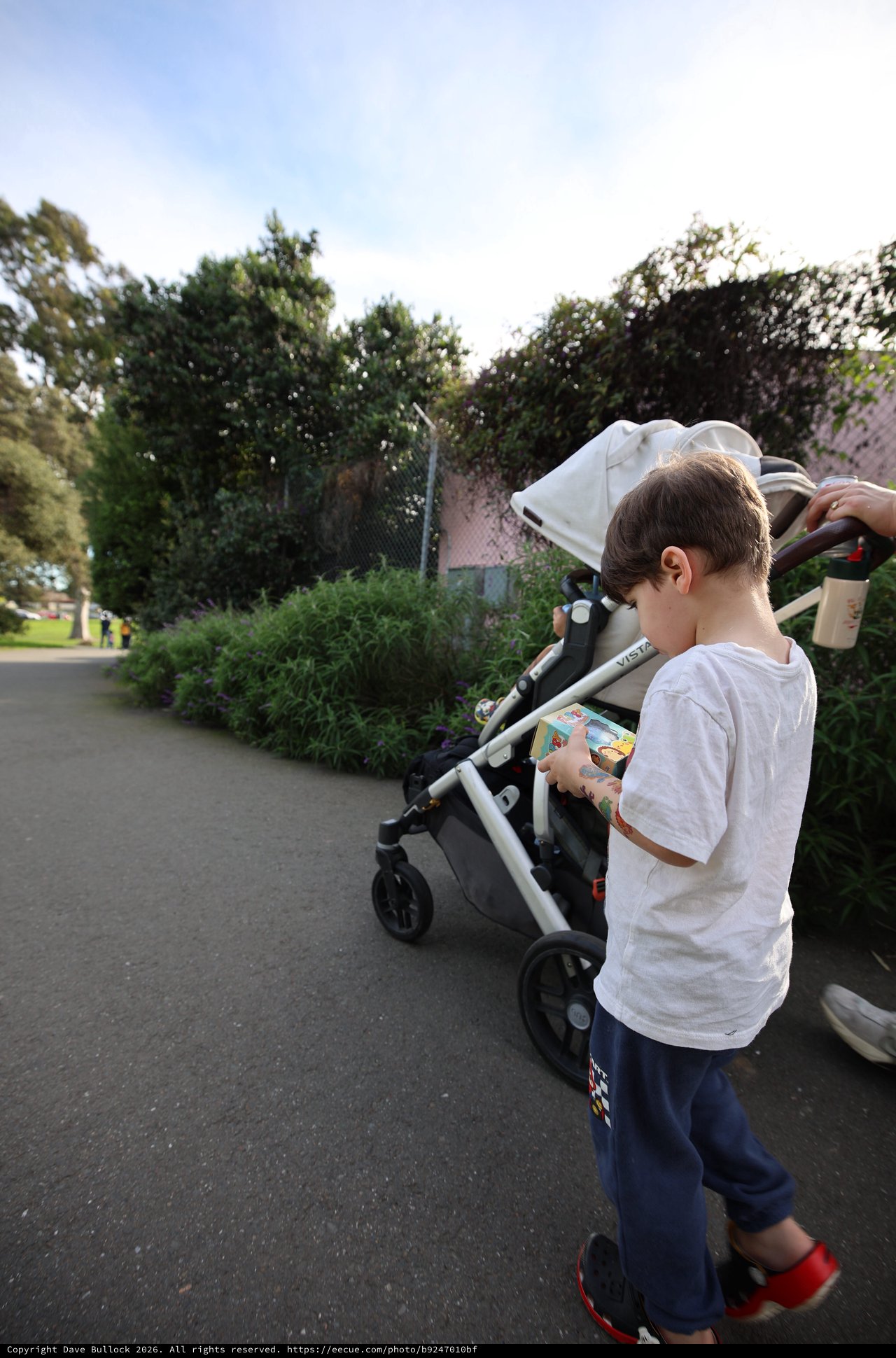 Young Boy with Snack by Stroller in Residential Area