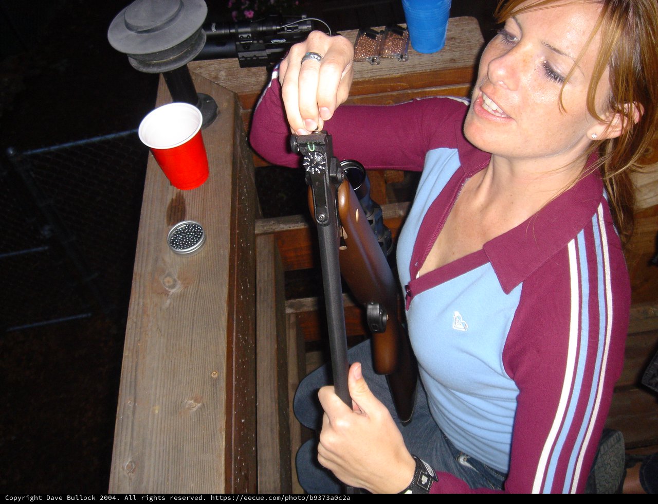 Woman Adjusting Sights on Air Rifle at Range