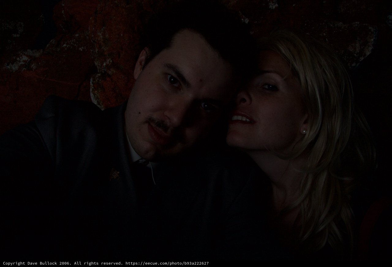 Dark Halloween Portrait of Couple Against Rustic Wall
