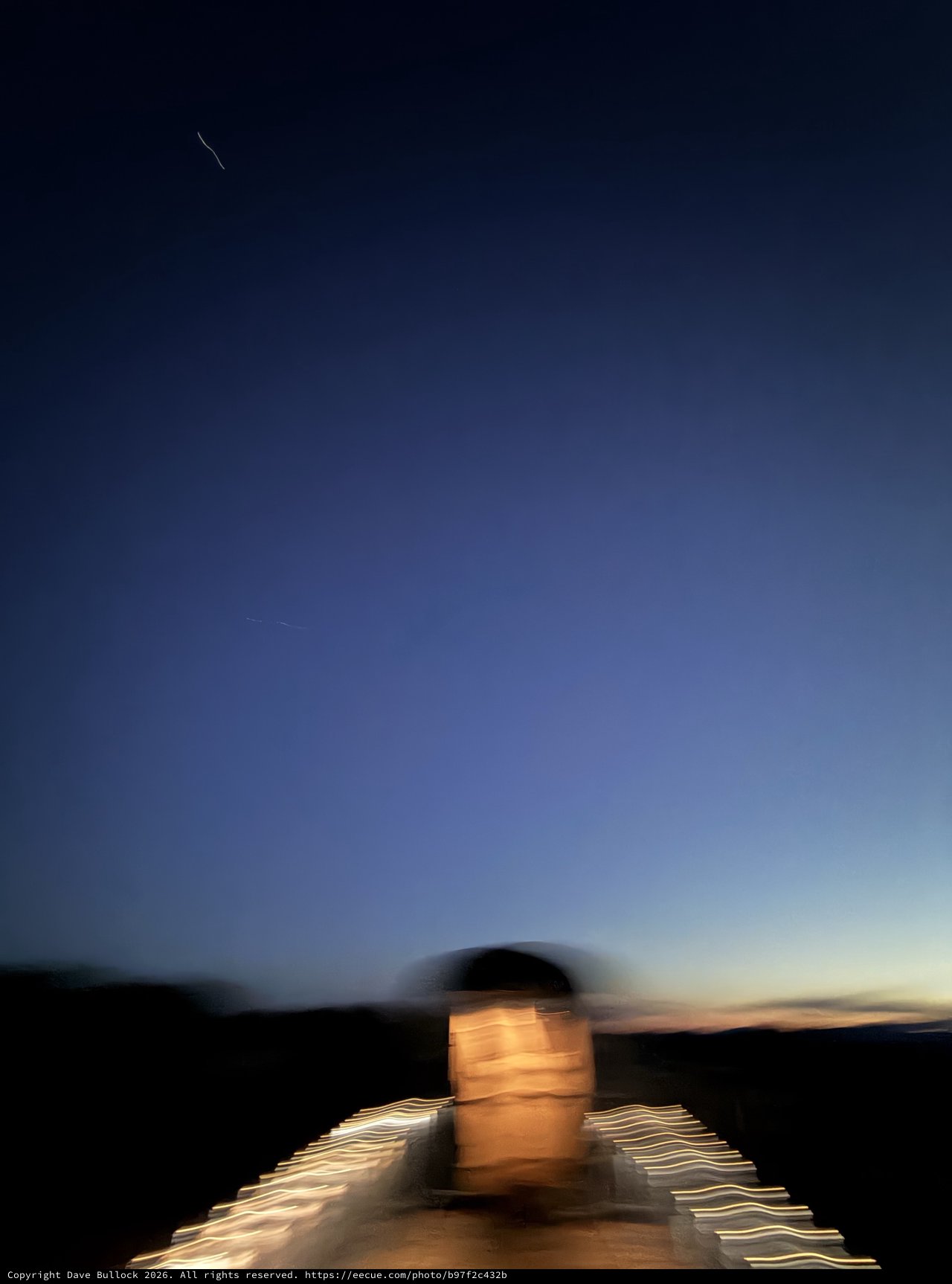 Motion-Blurred Self-Portrait at Twilight Over Desert Landscape