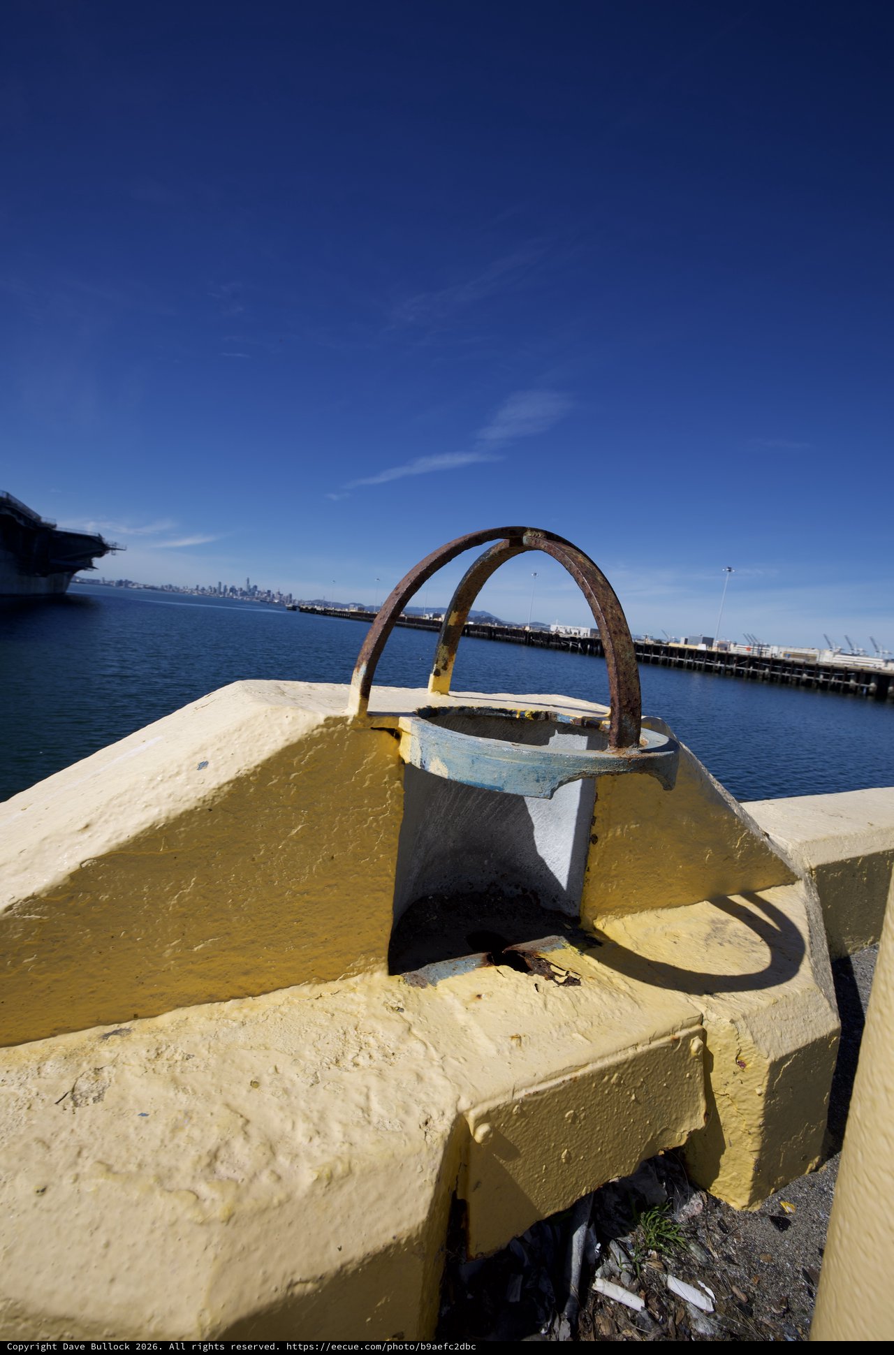 Rusted Mooring Bollard on Yellow Pier at Harbor