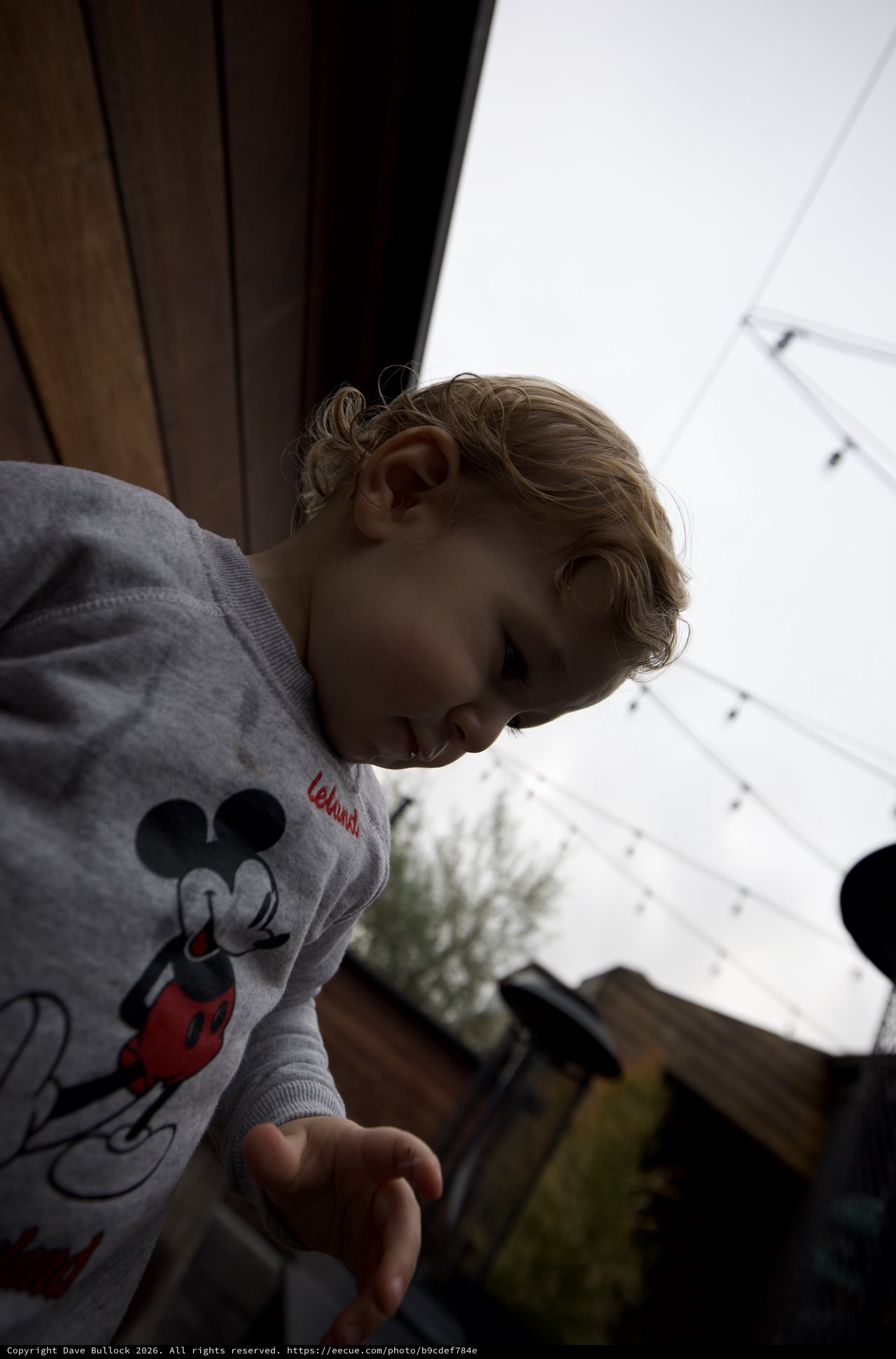 Young Child in Mickey Mouse Sweatshirt Looking Down