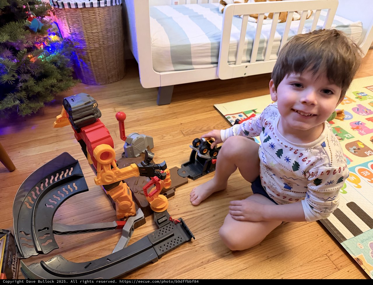 Happy Toddler Playing with Train Set on Christmas Morning