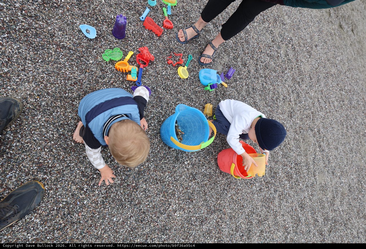 Children Playing with Beach Toys on Pebble Shore