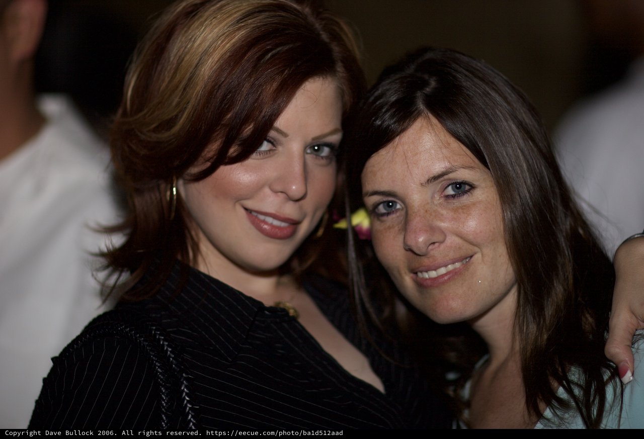 Two Women Smiling Together at Evening Social Event