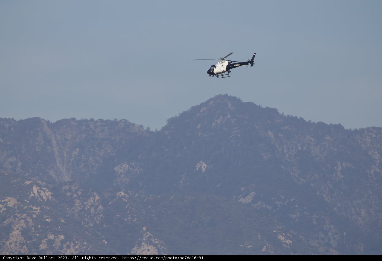 Soaring Majesty: Helicopter Over Mountain Range