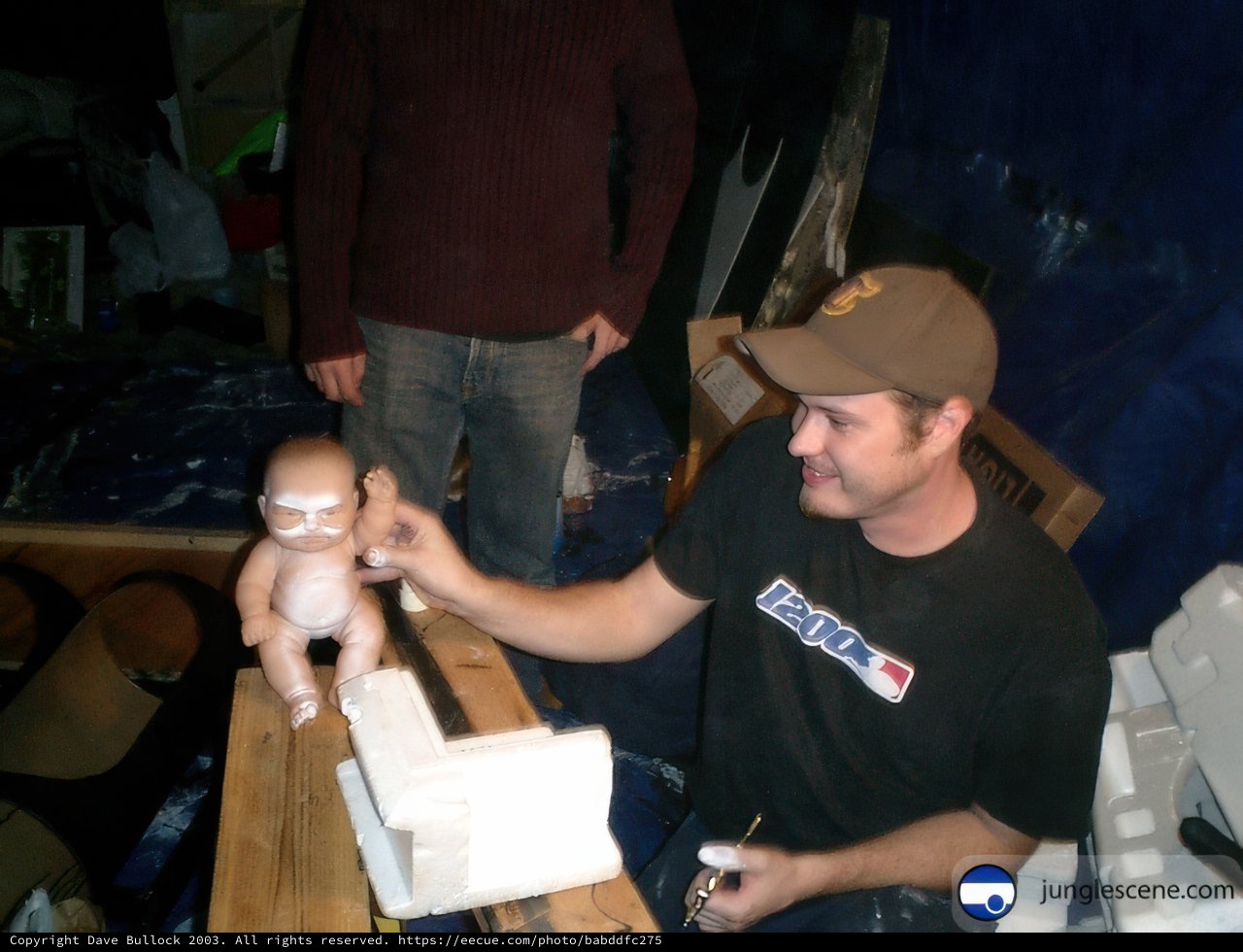 Man and Doll in front of Wooden Table