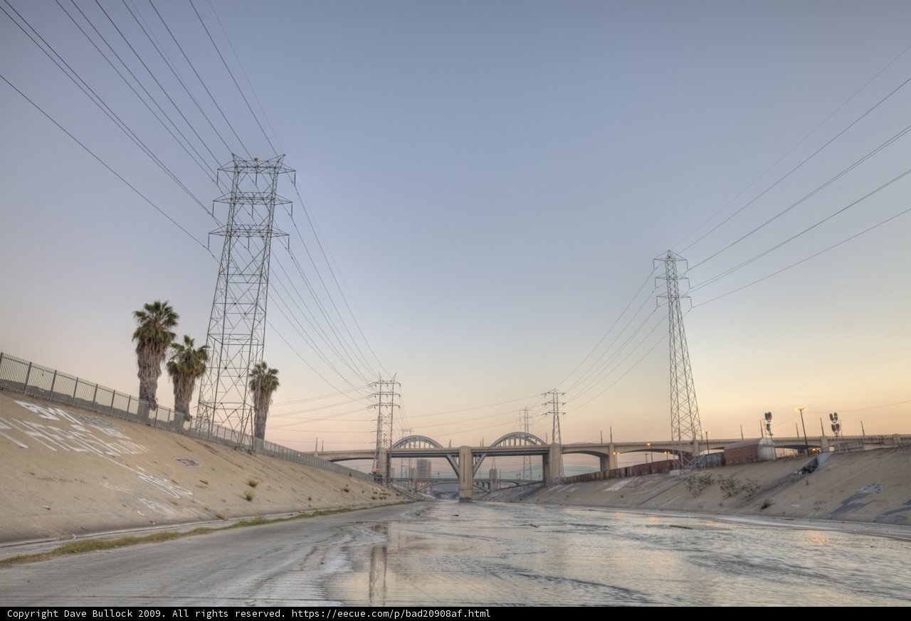Serene River View with Power Lines and Palm Trees
