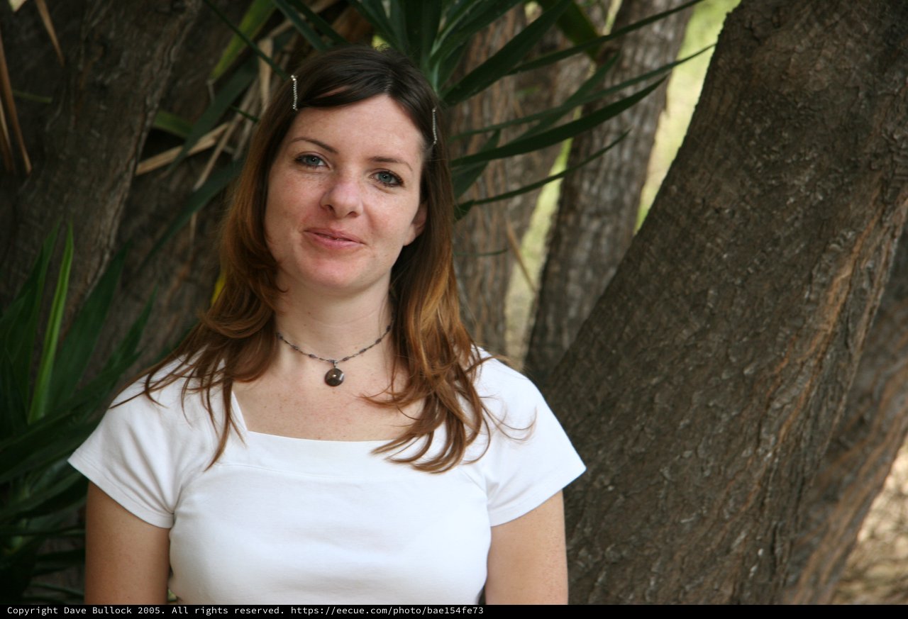 Woman Smiling Serenely Beneath a Shaded Tree