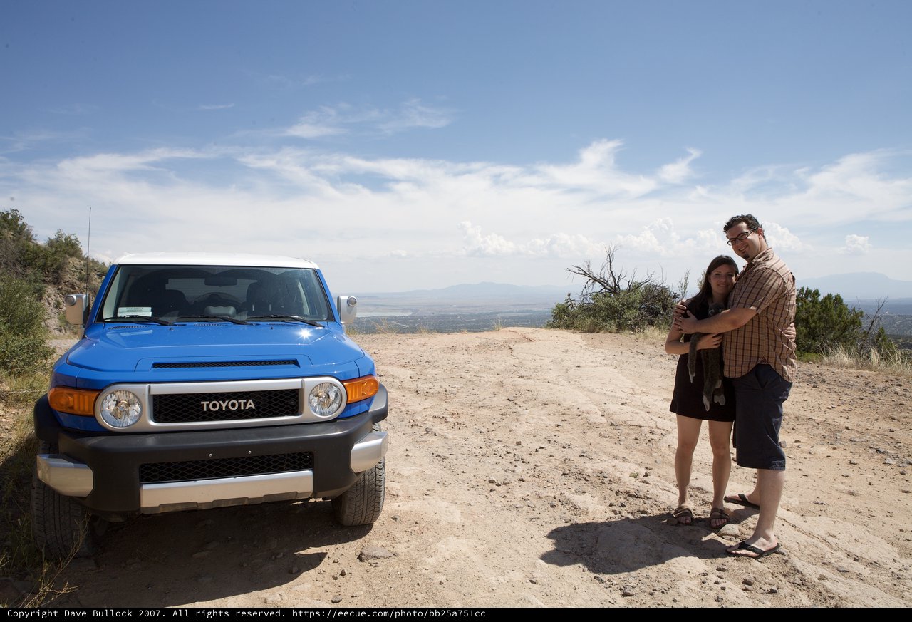 Couple Embracing Beside Blue Toyota FJ Cruiser Overlook