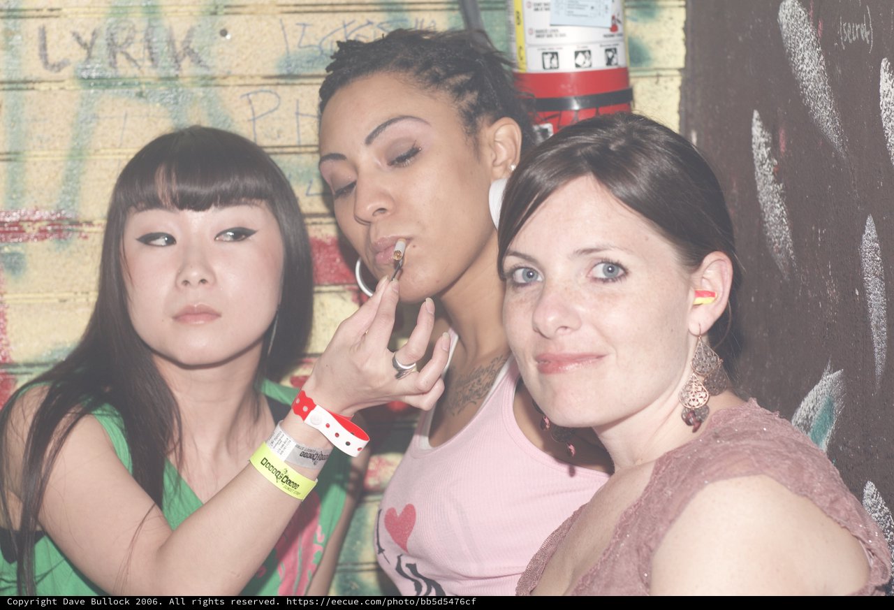 Three Women Posing at a Nightclub Graffiti Wall