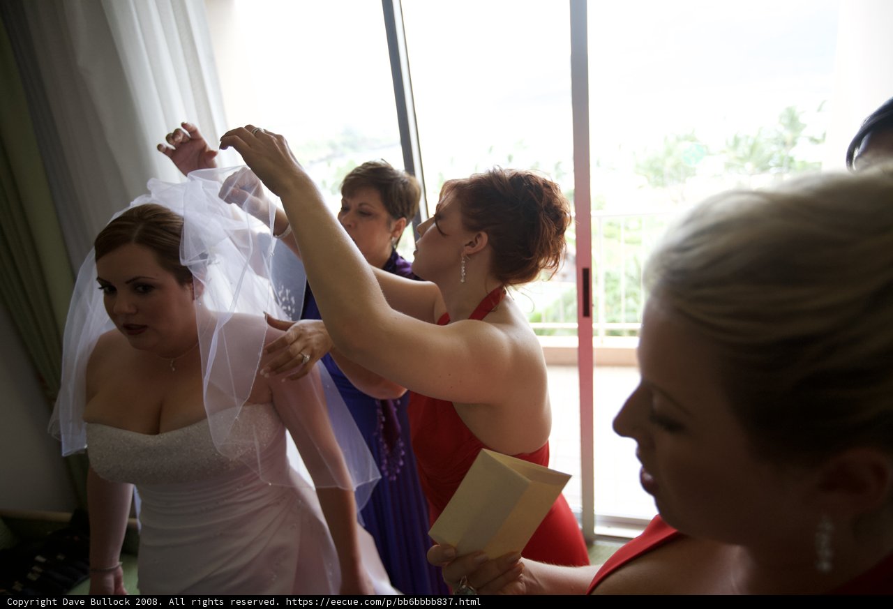 Bridesmaid Helps Bride into Elegant Wedding Gown