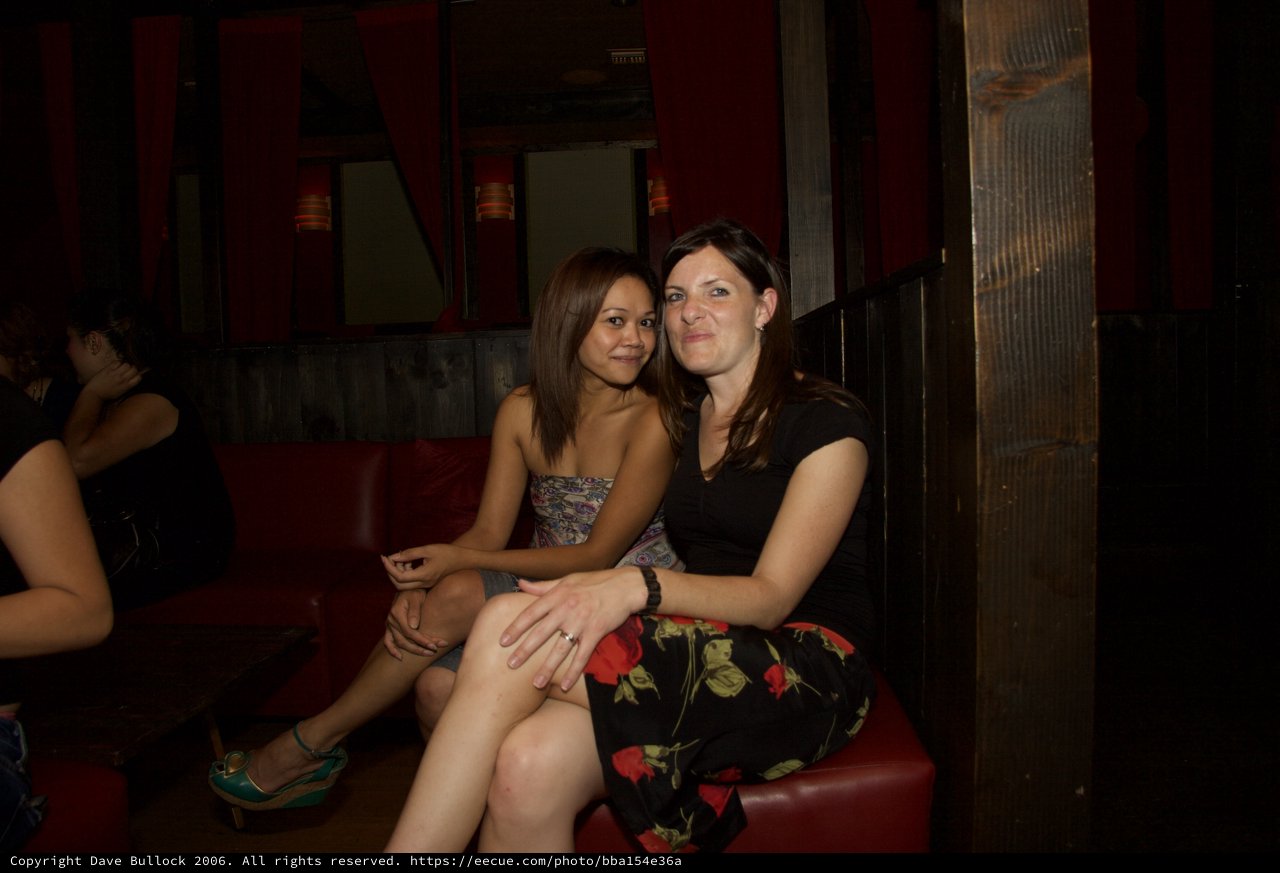 Two Friends Posing Together at a Nightclub Booth