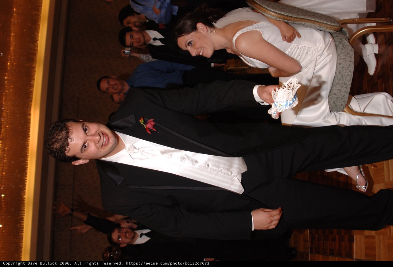 Groom Displays Wedding Garter at Reception Celebration