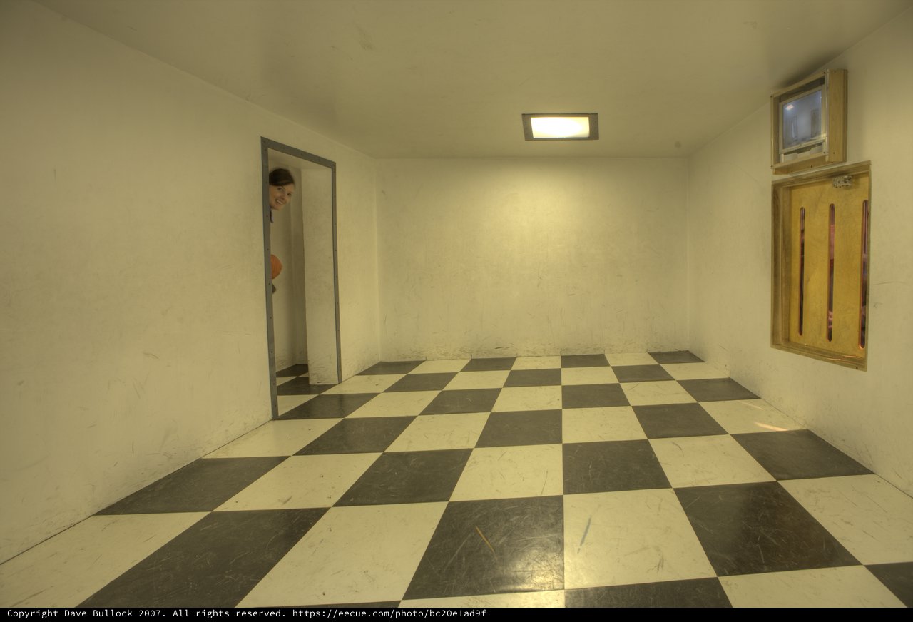 Mysterious Figure Peeks Through Empty Checkered Room