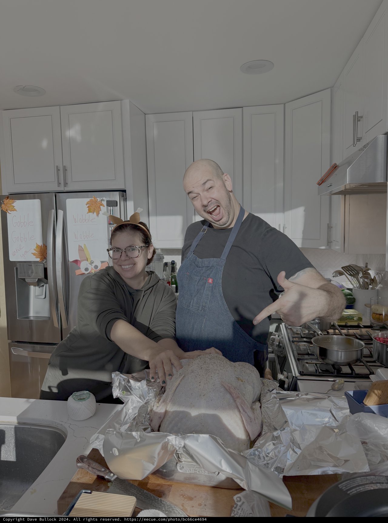 Couple Preparing Thanksgiving Turkey Together in Kitchen