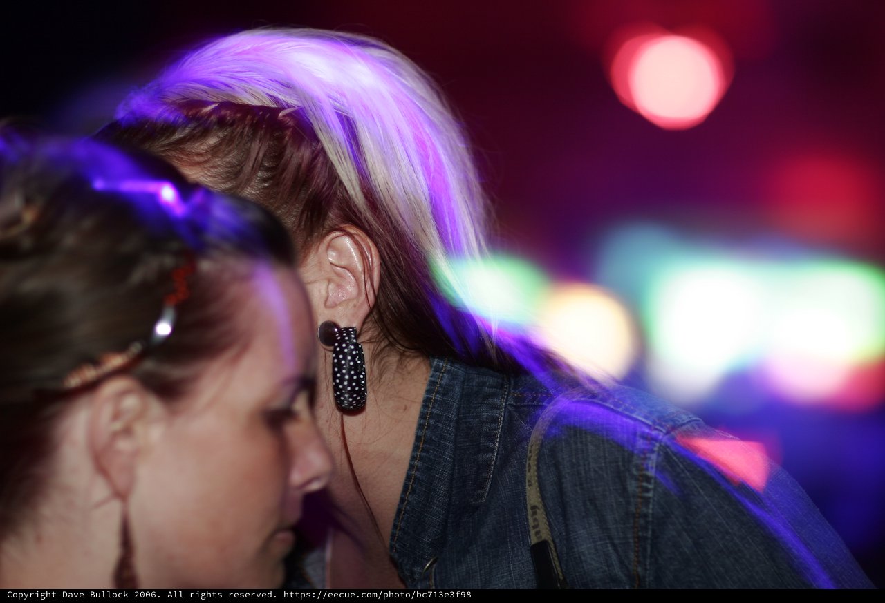 Two Women Dancing Under Neon Club Lights