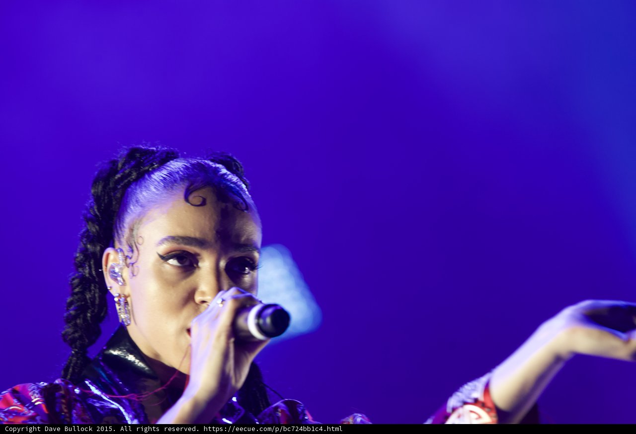 FKA twigs Incredible Close-Up Portrait Face Visible Arm Extended Dramatically Baby Hairs Elaborate Swirls Cat-Eye Makeup Hoop Earrings Black Choker Braided Ponytails Kimono Purple Blue Lighting Dynamic