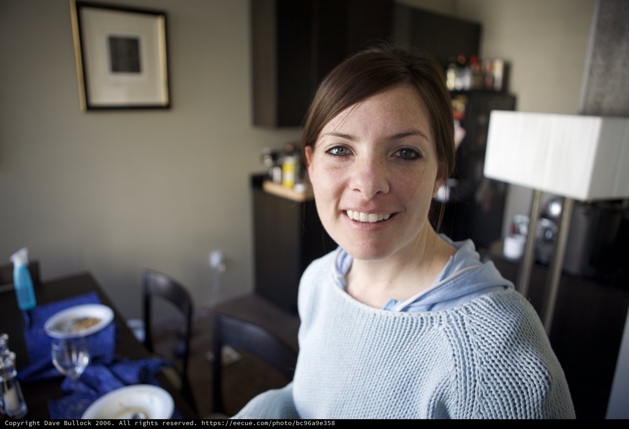 Smiling Woman in Blue Hoodie at Home