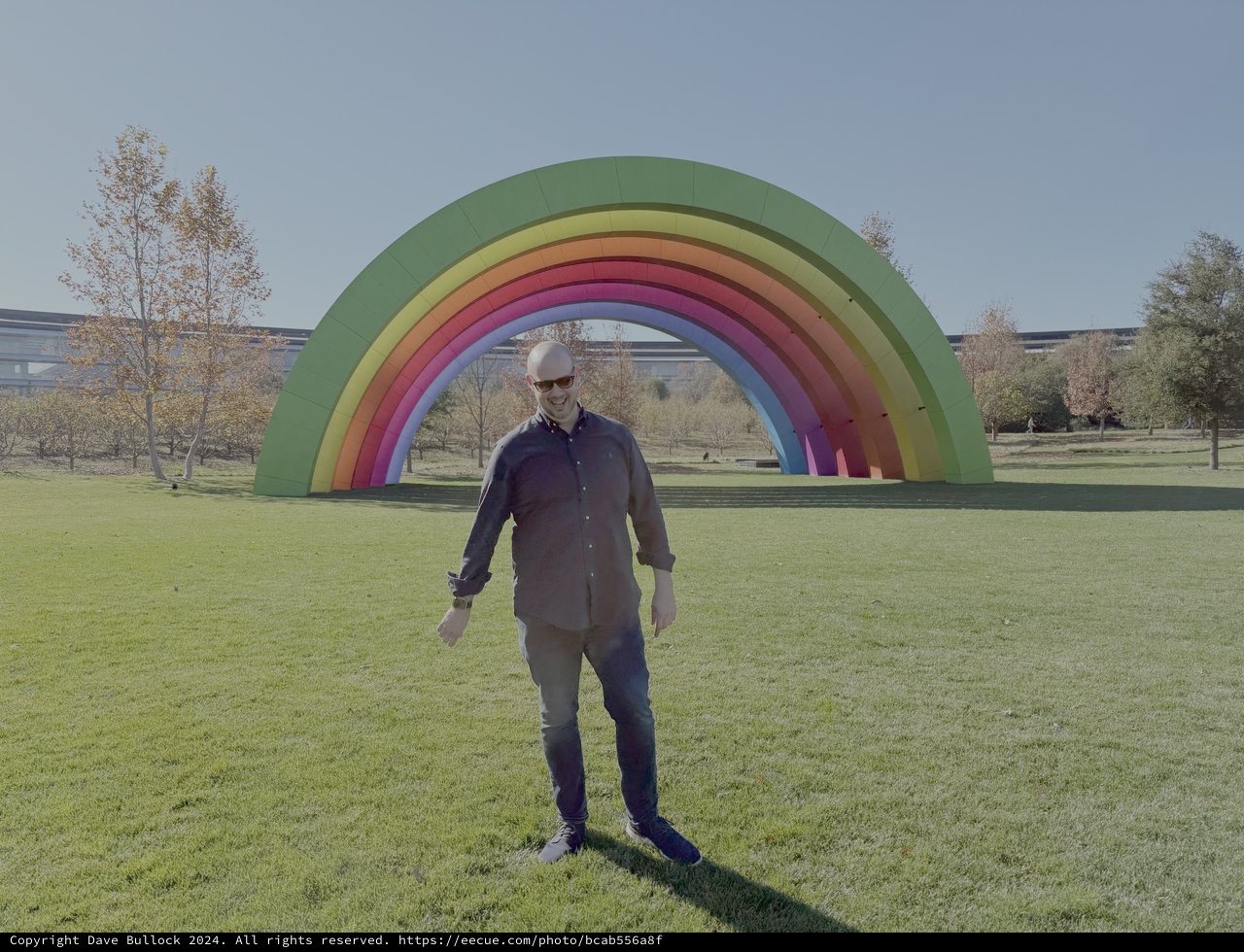 Person Standing Before Colorful Rainbow Art Installation