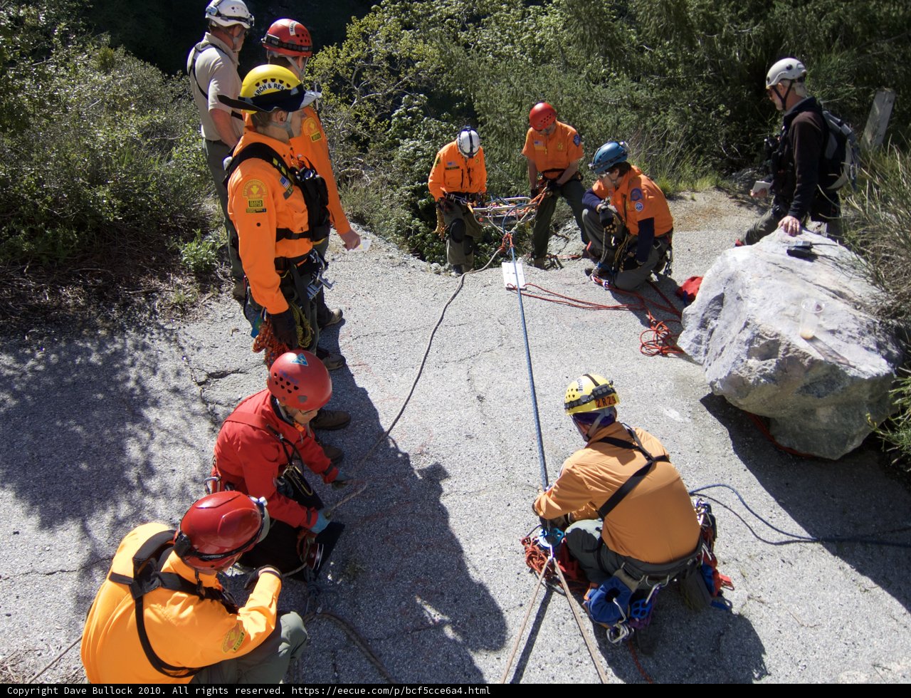 Orange-clad Rescuers Scaling Rocky Terrain