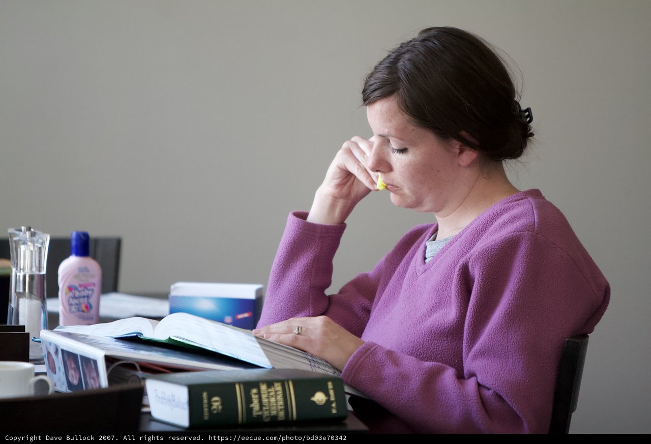 Woman Deeply Focused While Studying Medical References