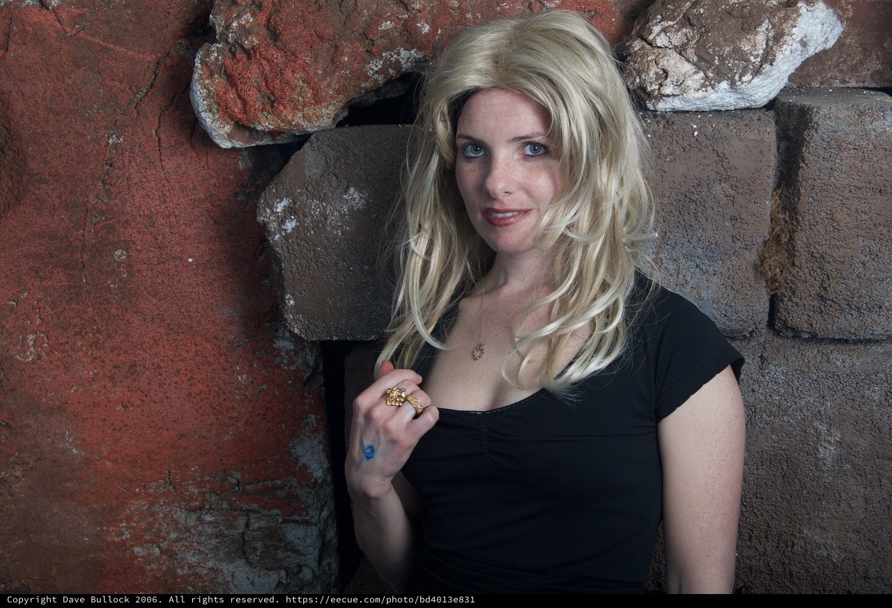 Blonde Woman Leaning Against Rustic Stone Wall