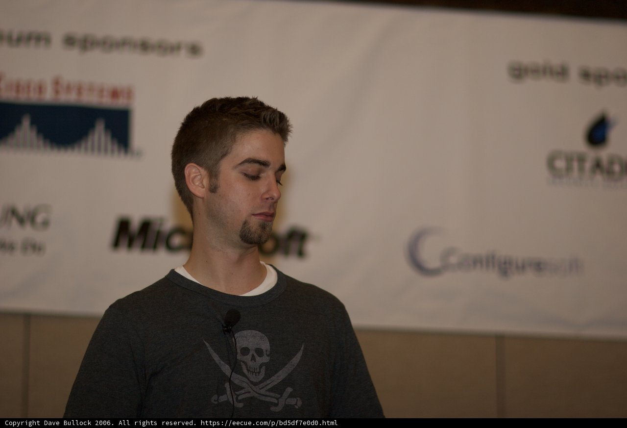 Man Speaking in Front of Banner