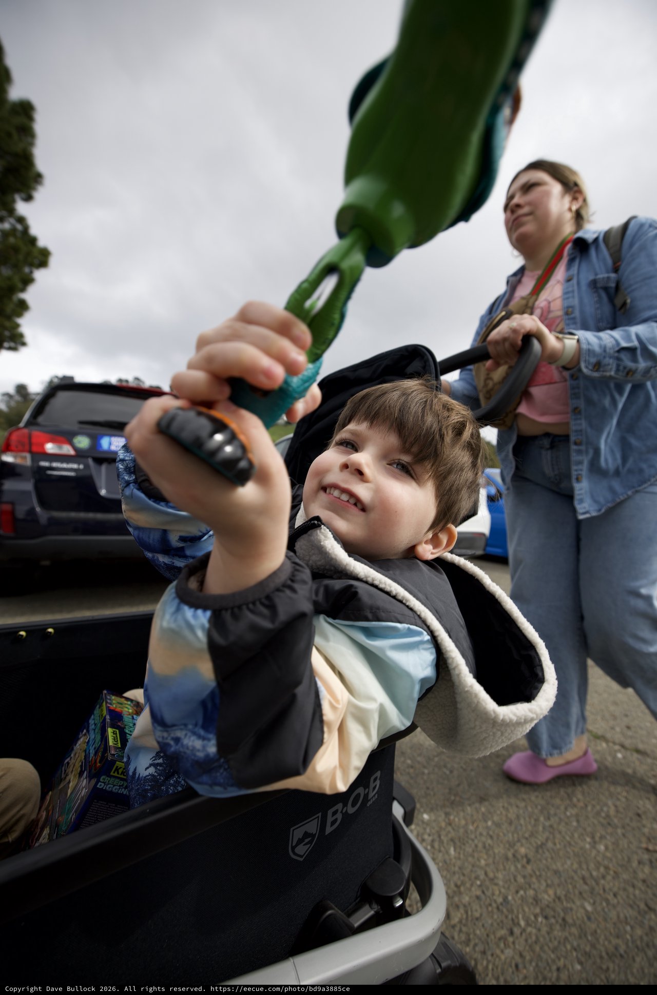 Young Boy with Dinosaur Toy at Parking Lot Gathering