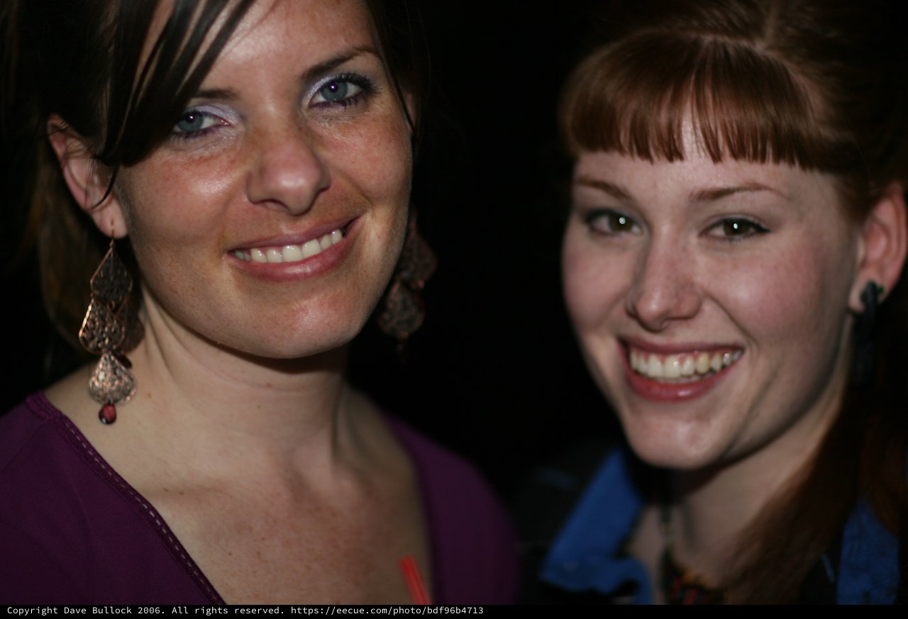 Two Smiling Women at a Nighttime Social Event