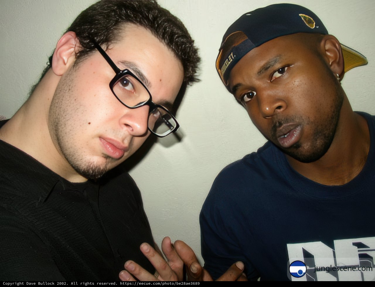 Two Men in Glasses and Hats Pose for a Portrait
