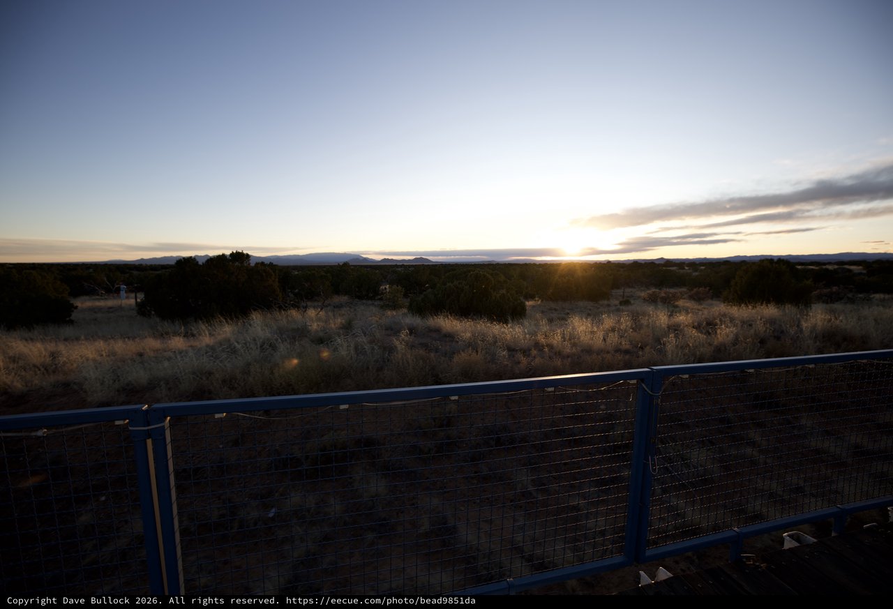 Sunset Over Desert Landscape with Metal Fence