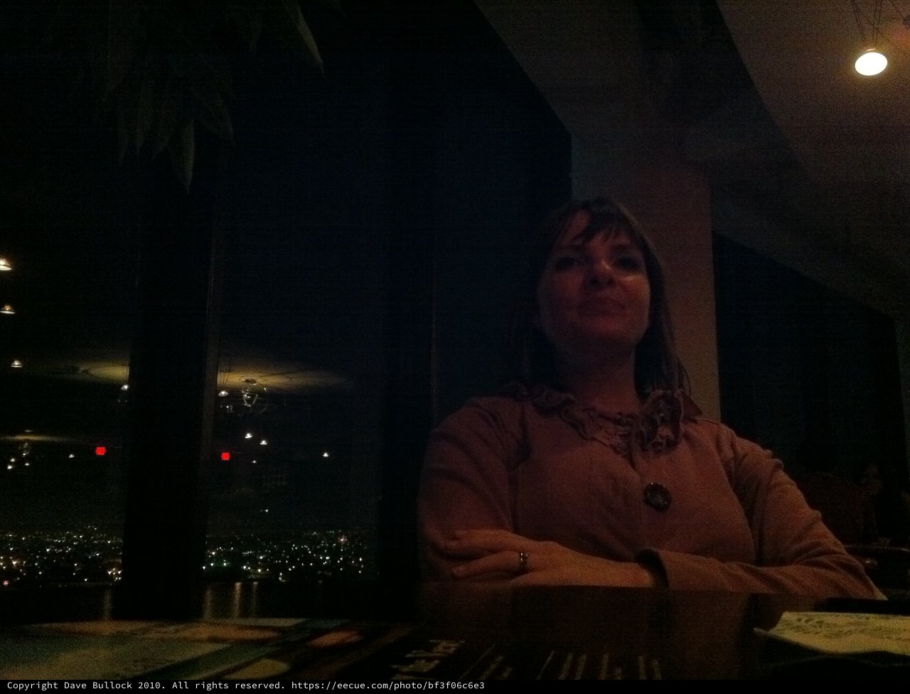 Contemplative Woman at Dimly Lit Urban Restaurant