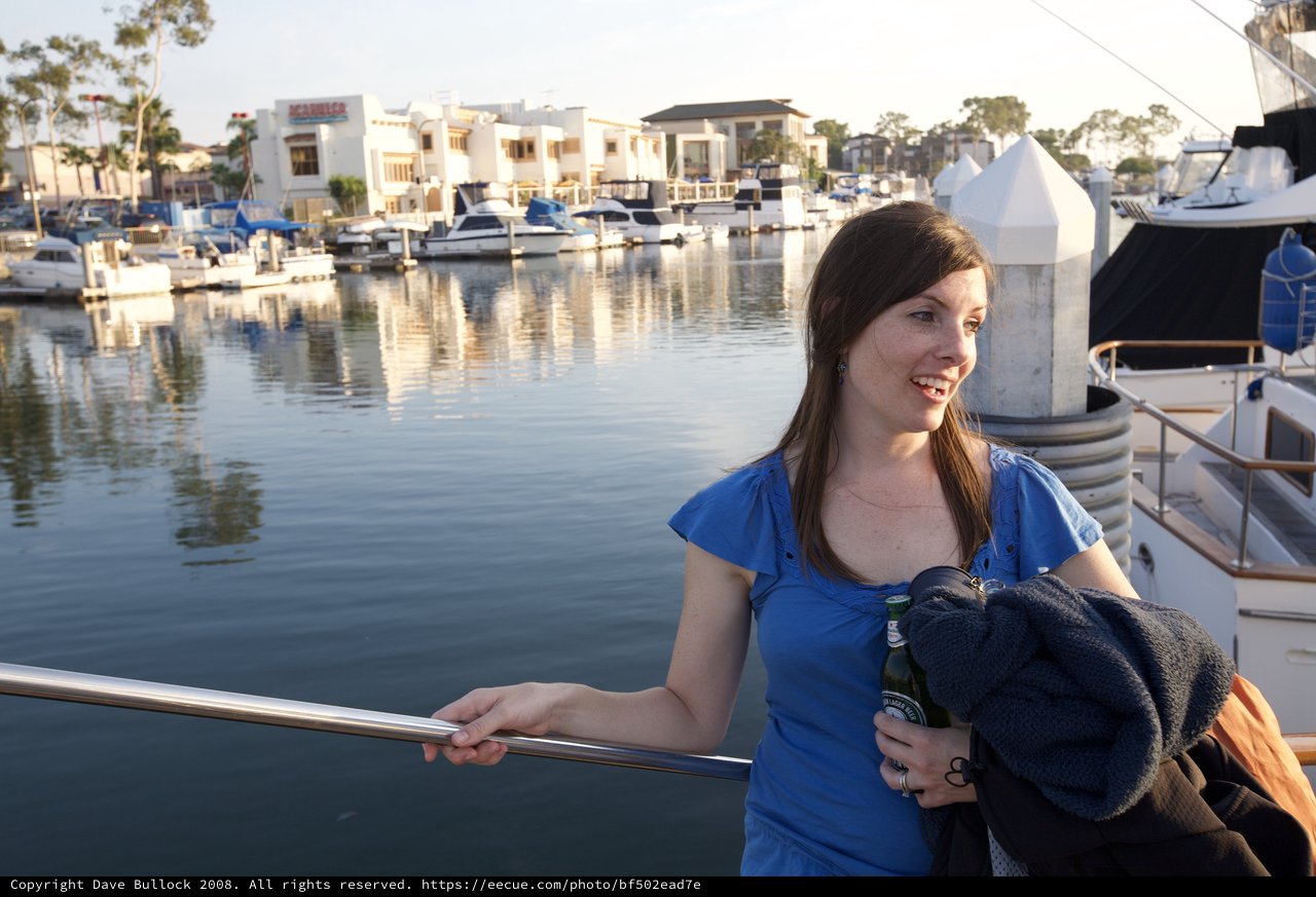 Woman Relaxing at Marina with Beer at Sunset