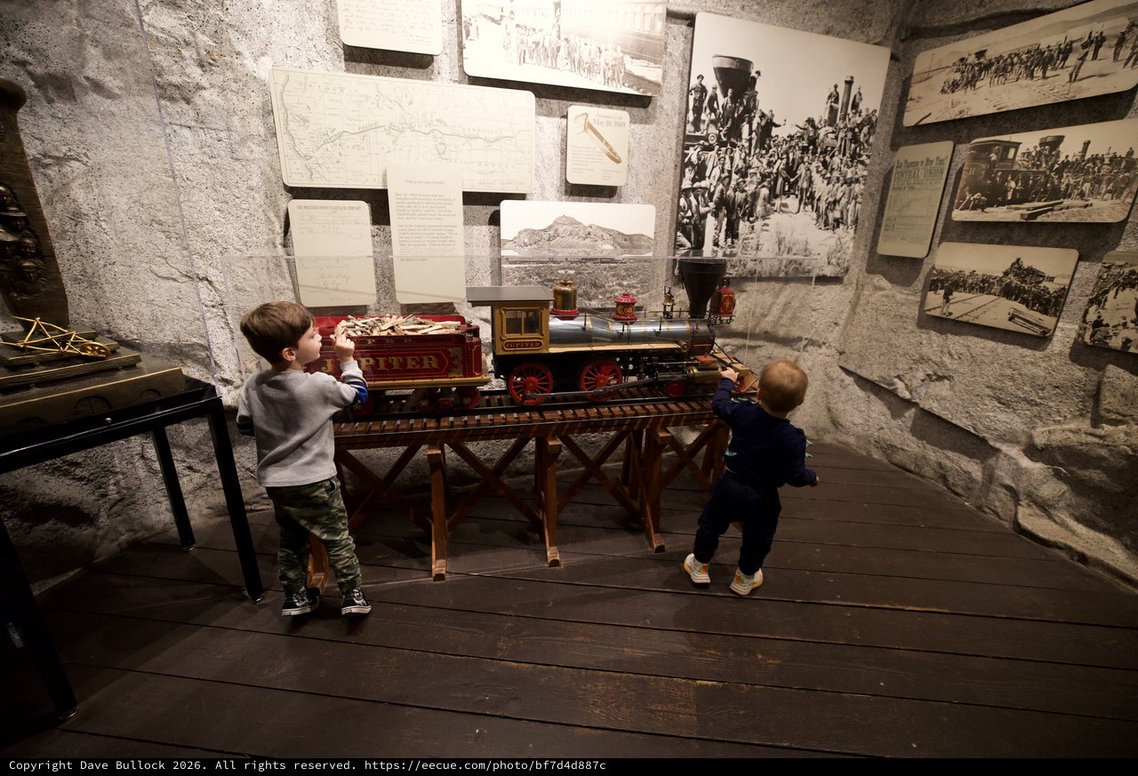 Children Exploring Historic Train Exhibit in Museum