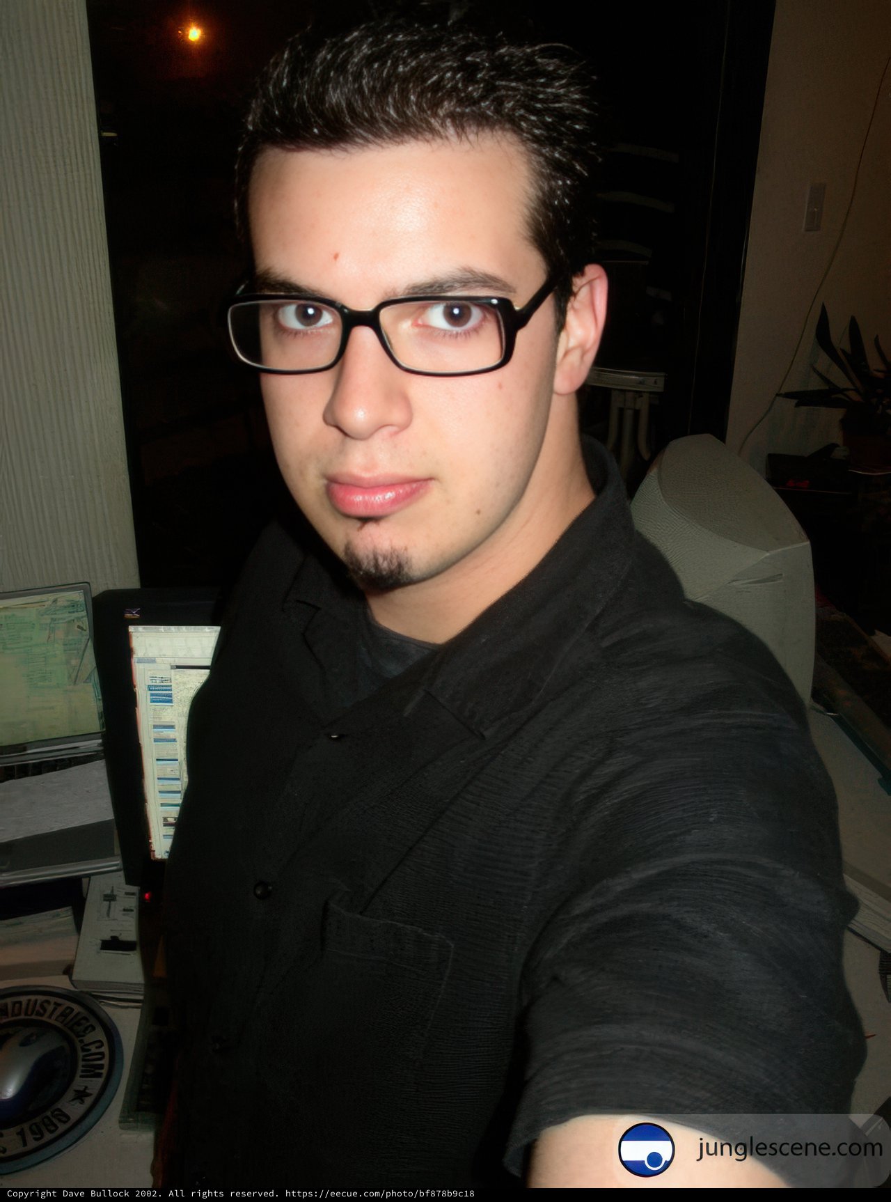 Three Monitors and a Man in Glasses