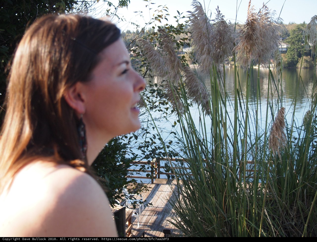 Contemplative Woman by Lakeside Dock at Golden Hour