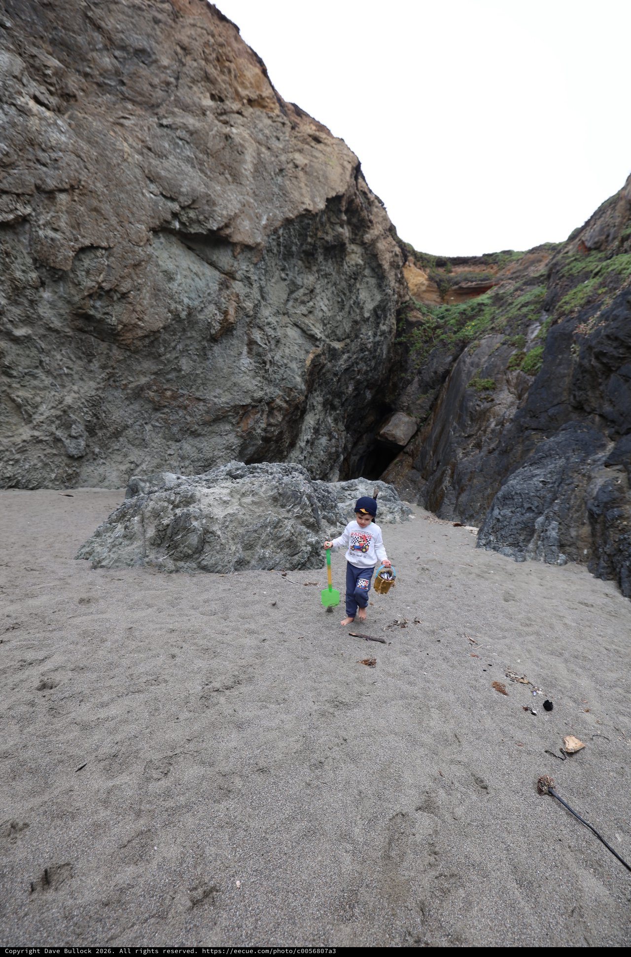 Young Explorer Discovers Sea Cave on Rocky Beach