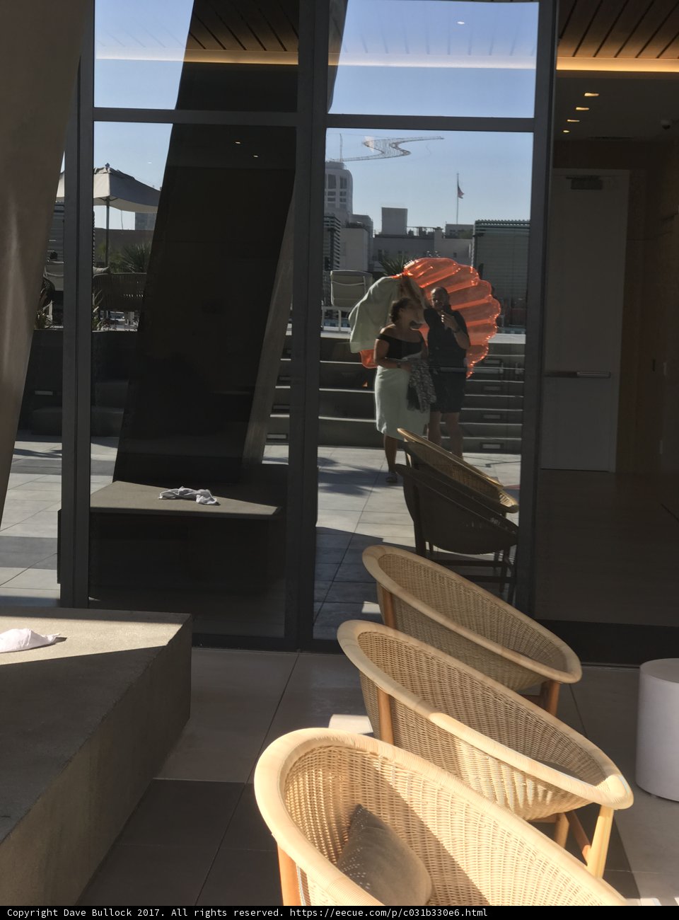Woman with Umbrella in Front of Plywood Building