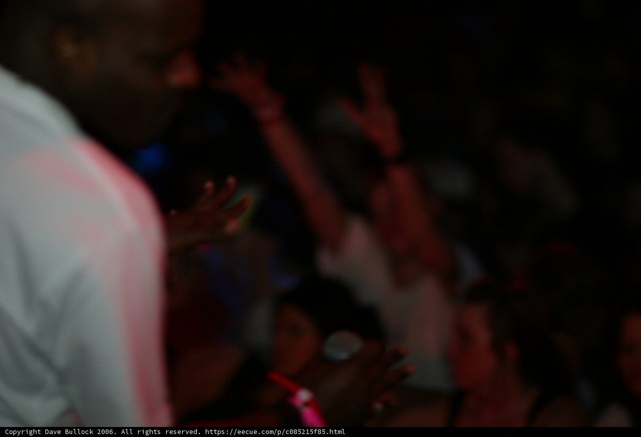 Man Holds Up Hands in Night Club Crowd