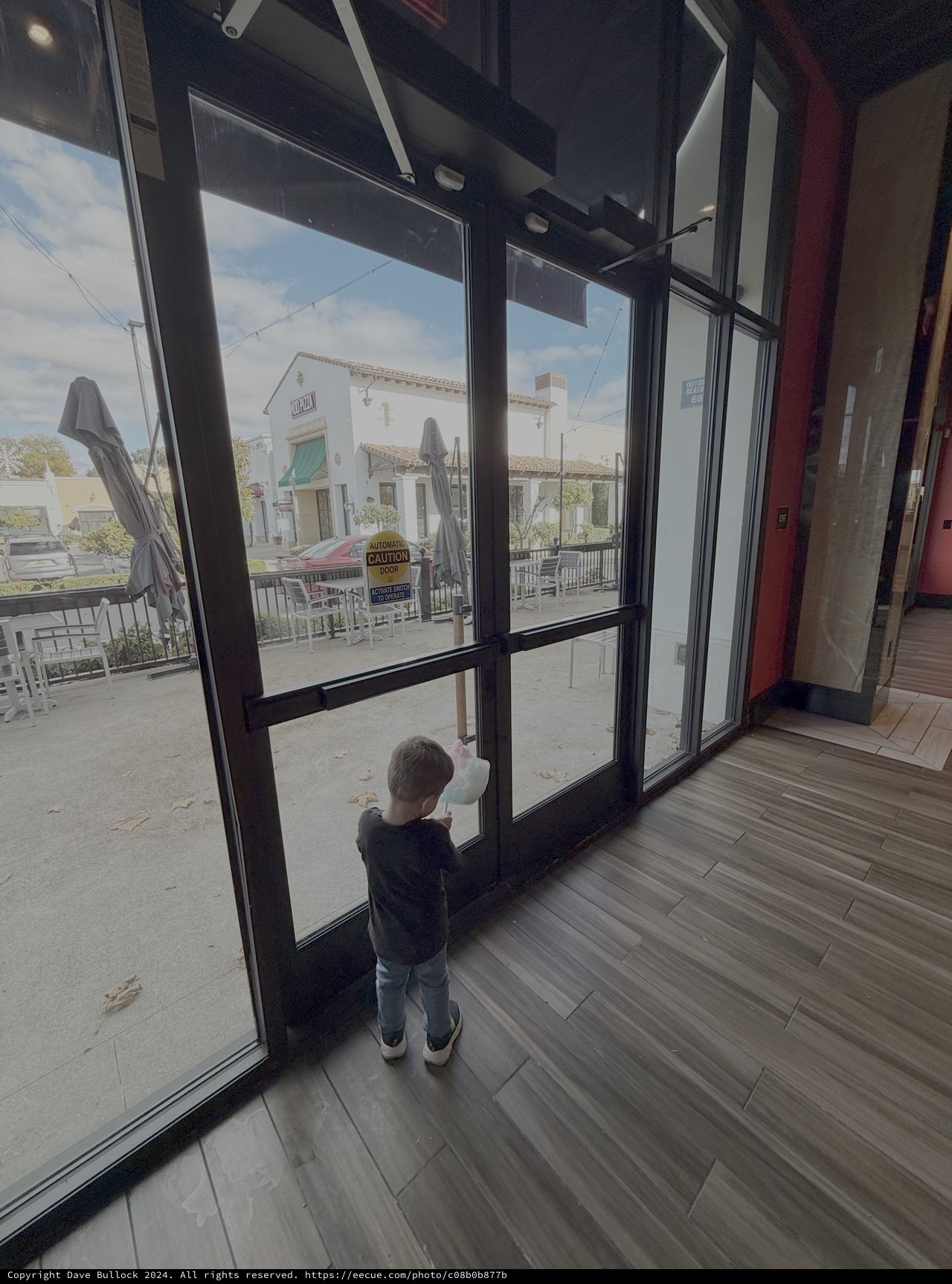 Child Gazing Through Restaurant Glass Doors