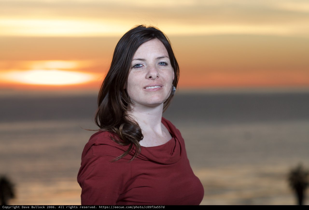 Woman Smiling Against a Golden Coastal Sunset