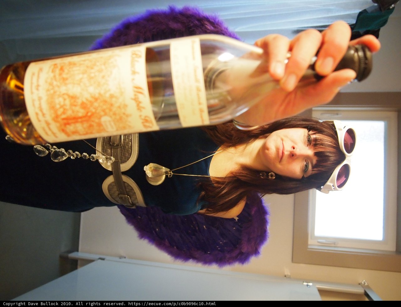 Woman enjoying a bottle of wine by the window