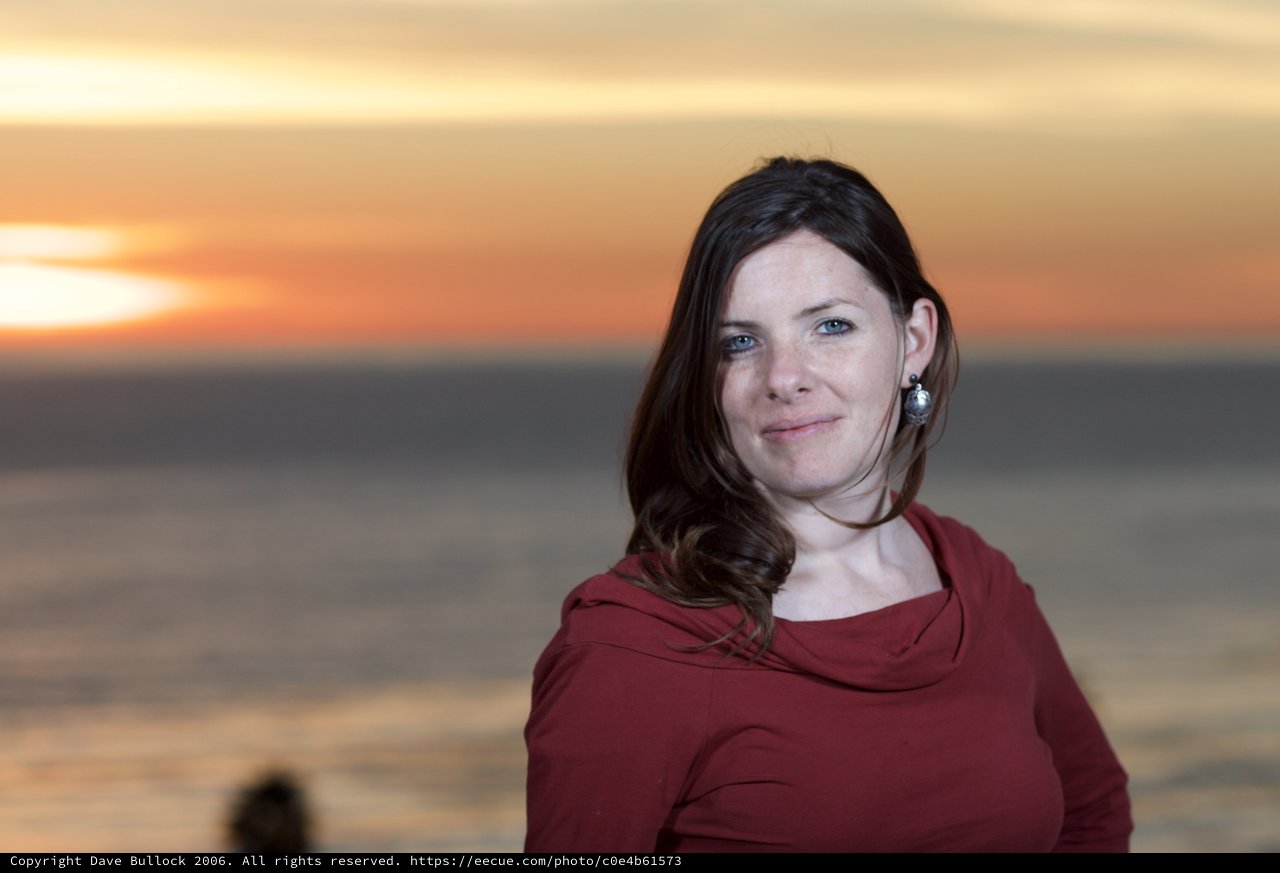 Woman Smiling at Sunset by the Sea