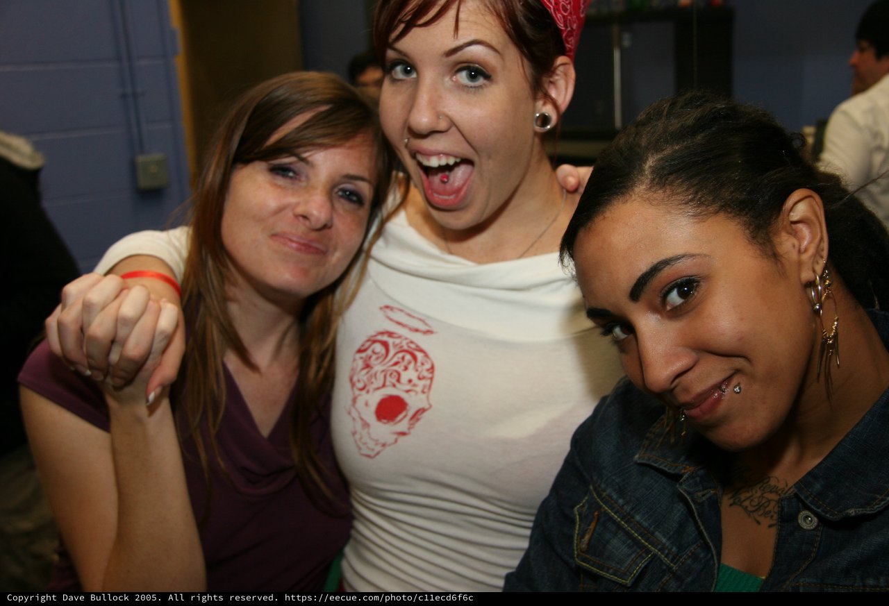 Three Friends Pose Together at a Party