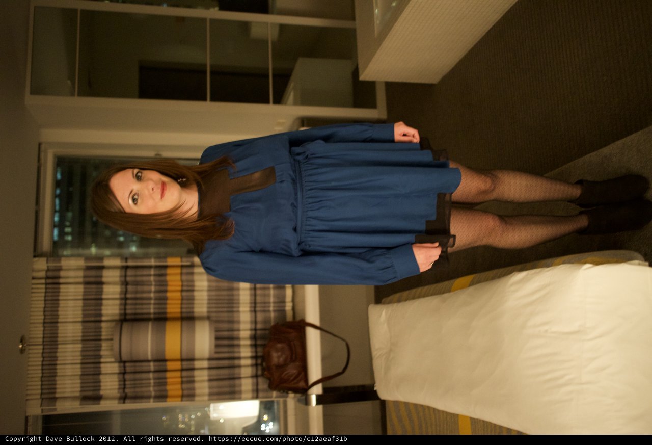 Woman in Blue Dress Poses in Modern Hotel Room