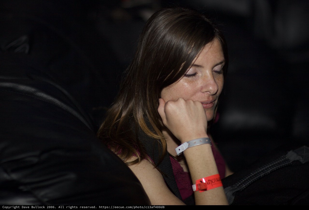Contemplative Woman at Darkened Event Venue